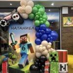 Тематична декорация за детски рожден ден Minecraft с арка от балони, персонализиран фон, фигури на Creeper и TNT и украса за шестия рожден ден на Натаниел.